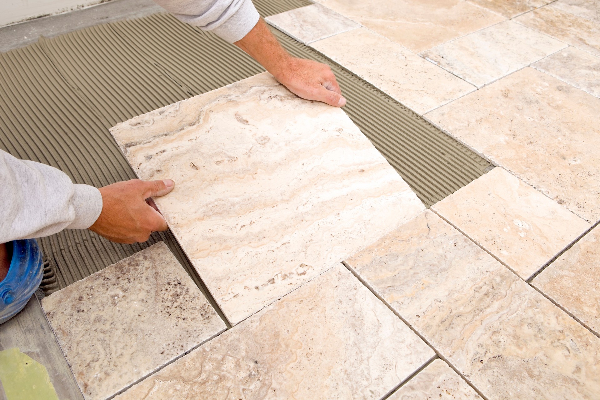 Worker Places New Marble Tile on a Bathroom Floor